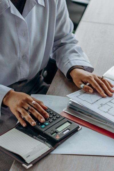 An advisor working through files with a calculator